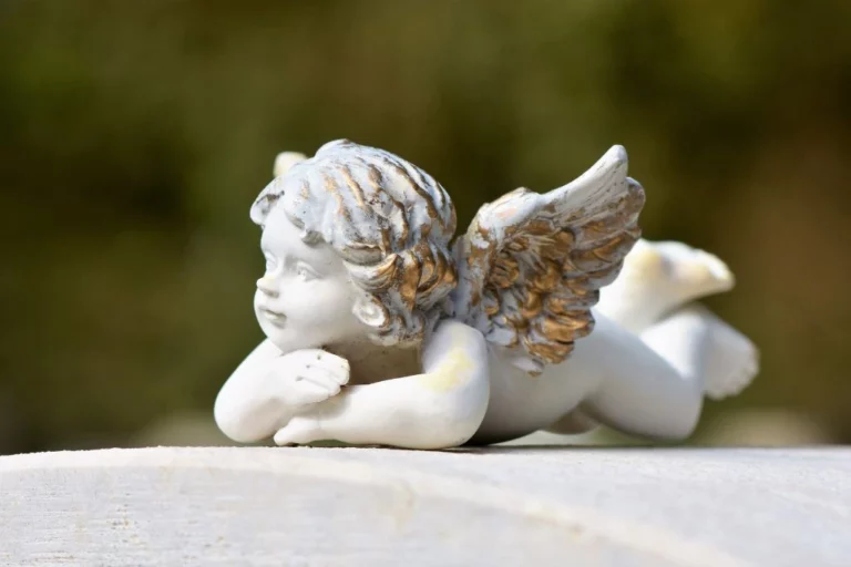 a statue of a baby angel on a concrete