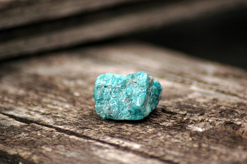 a blue apatite crystal on a wooden table