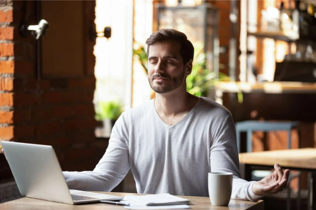 A calm person in a cafe taking deep breaths as he control his emotions