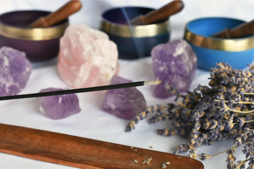 incensing around crystals and singing bowls and a flower