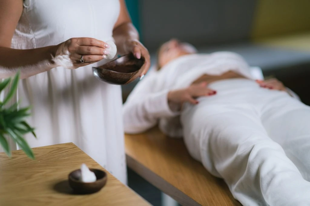 Woman holding crystal and a woman lying down for crystal therapy