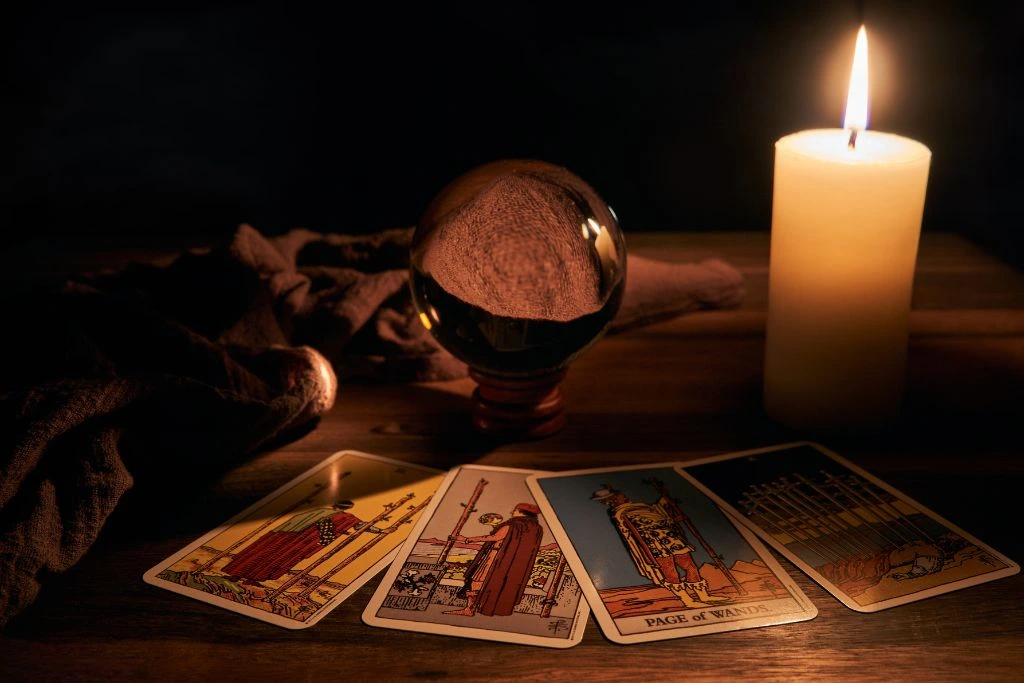 Tarot cards, crystal ball and a candle on the table