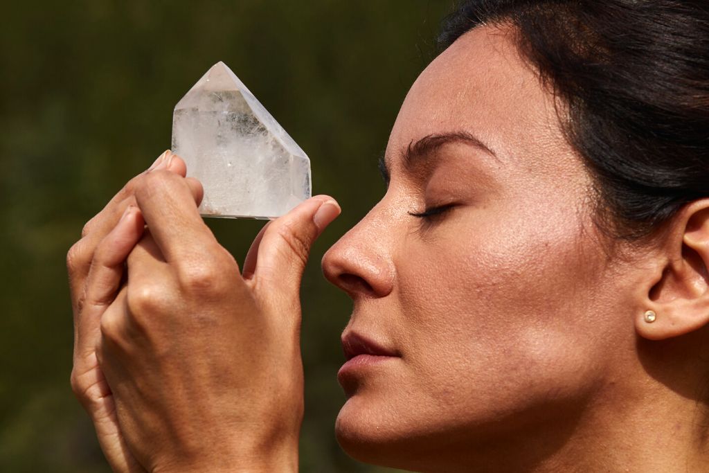 woman meditating with a crystal by humming and chanting