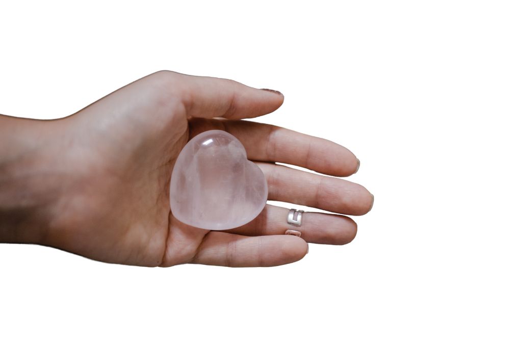 selenite crystal held in a human palm on a white background