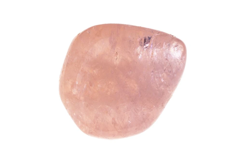 A polished morganite crystal on a white background