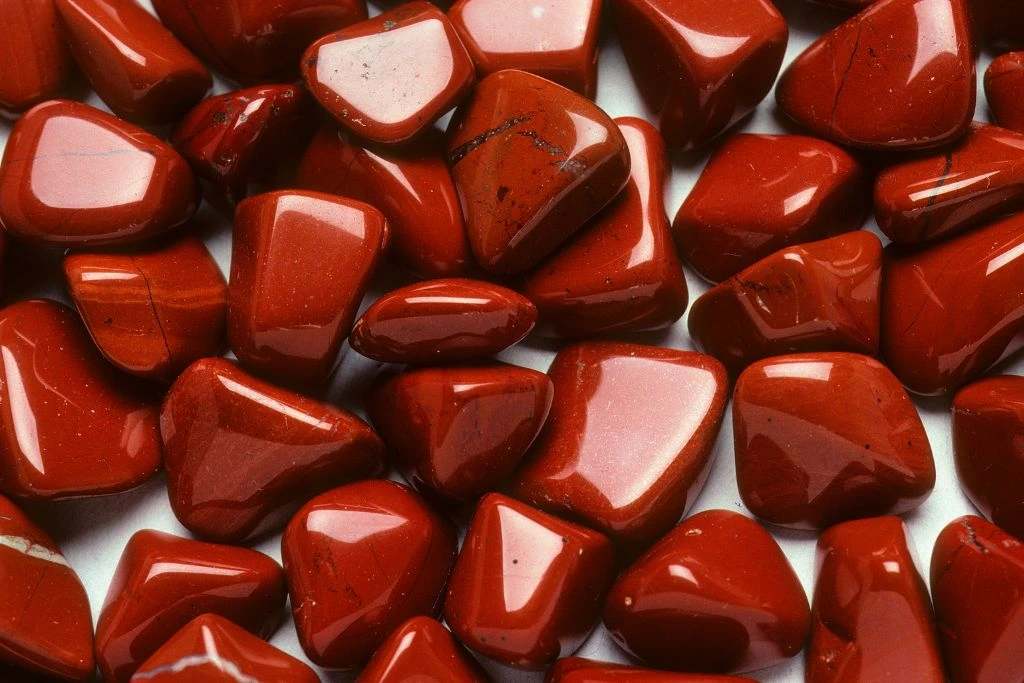 different cuts of red jasper crystal on a white background