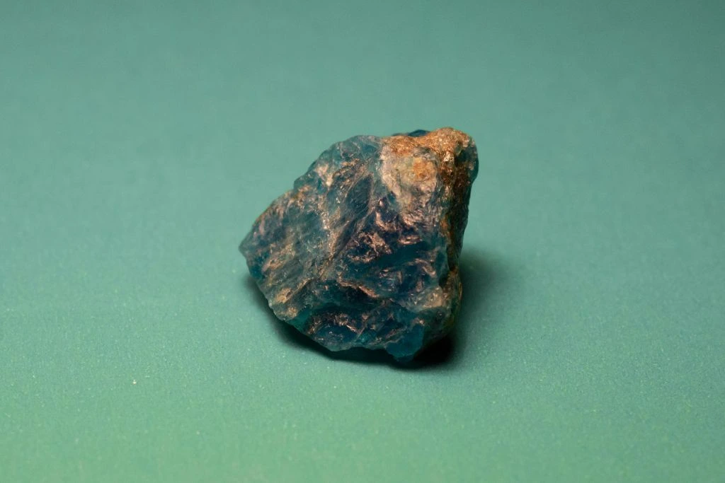 A rough Apatite crystal on a greenish background