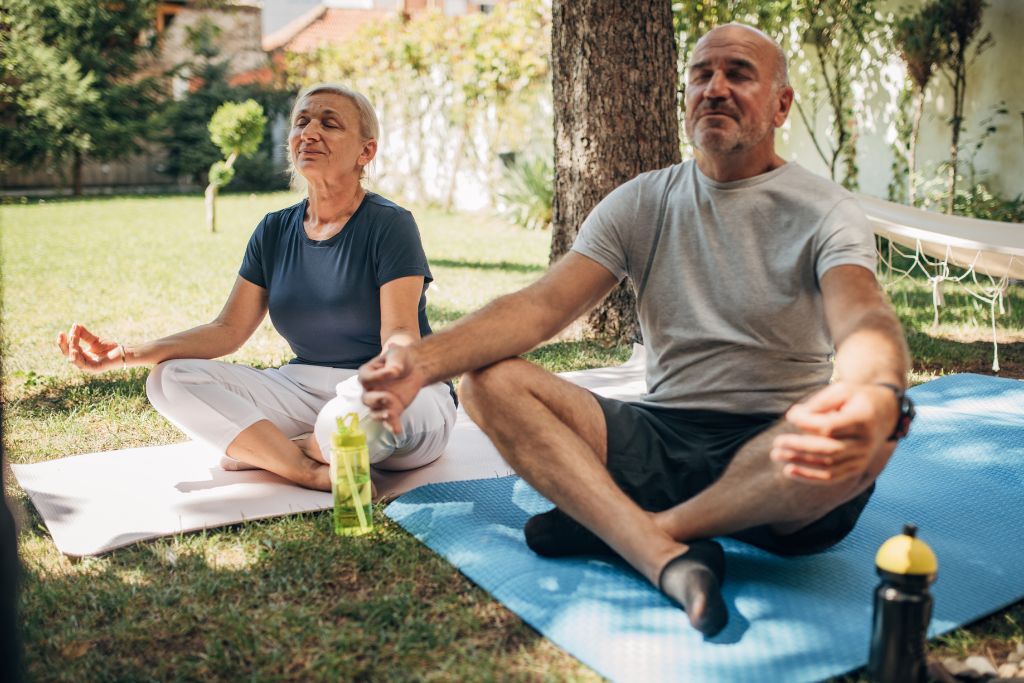 senior couple meditating in an outdoor setting