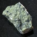 A raw serpentine crystal on a dark granite