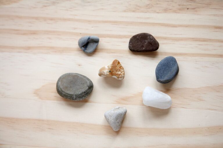 worry stone together with gemstone chips on wooden table