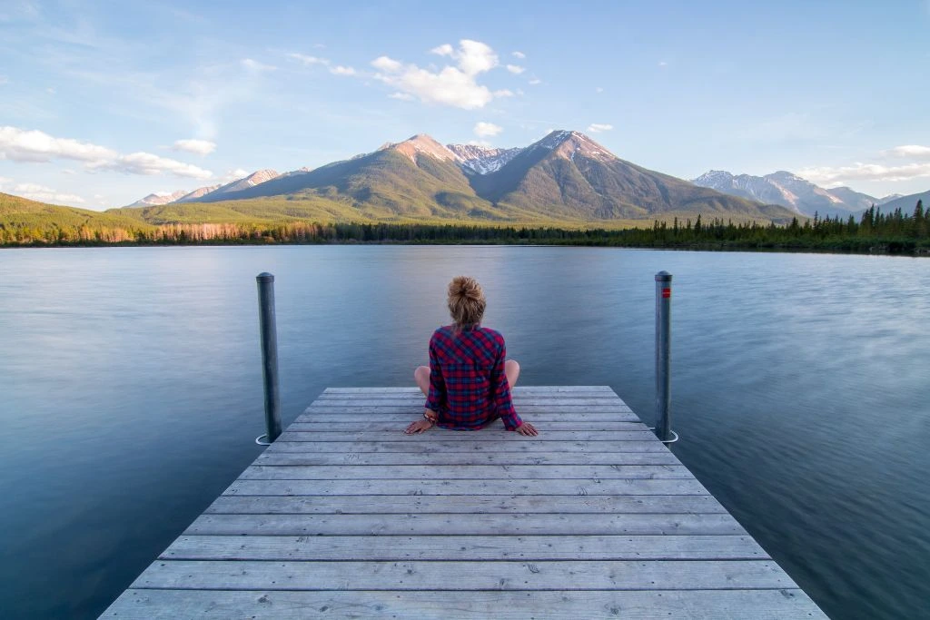 A woman sitting at the end of the dock