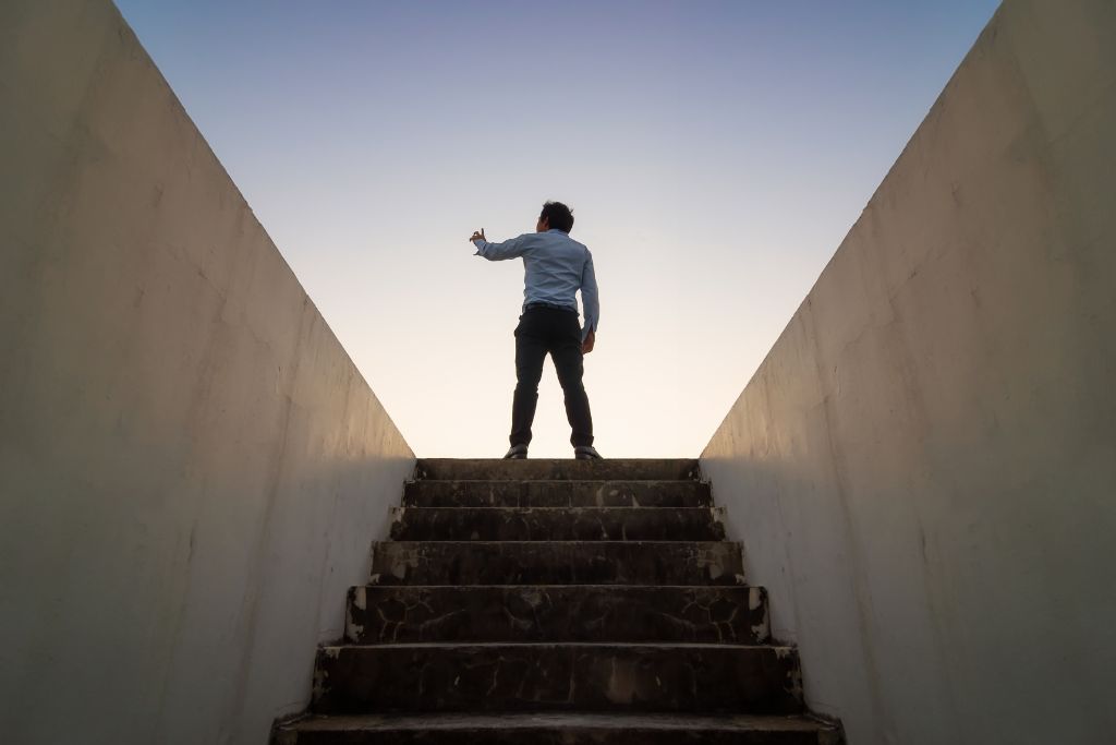 A man reach the top of the stairs