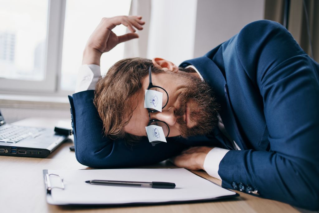 A man is sleeping on the table while working