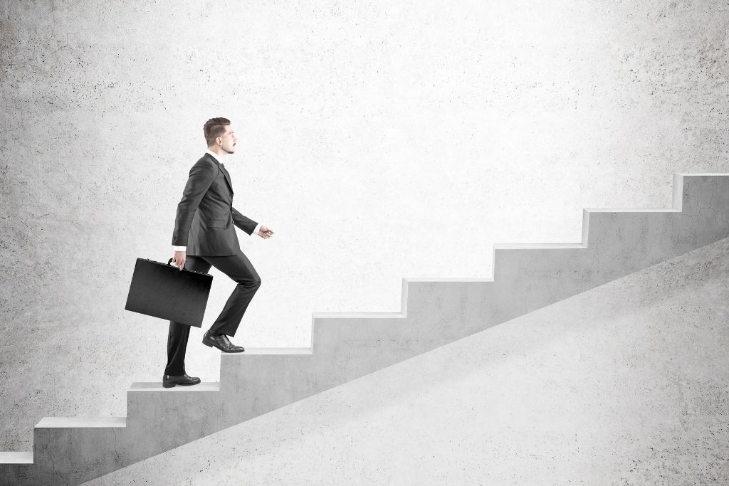 A corporate man walking up the stairs