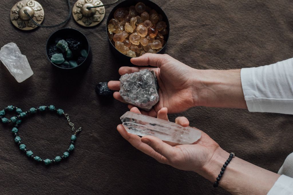 A person holding different crystals for chanting