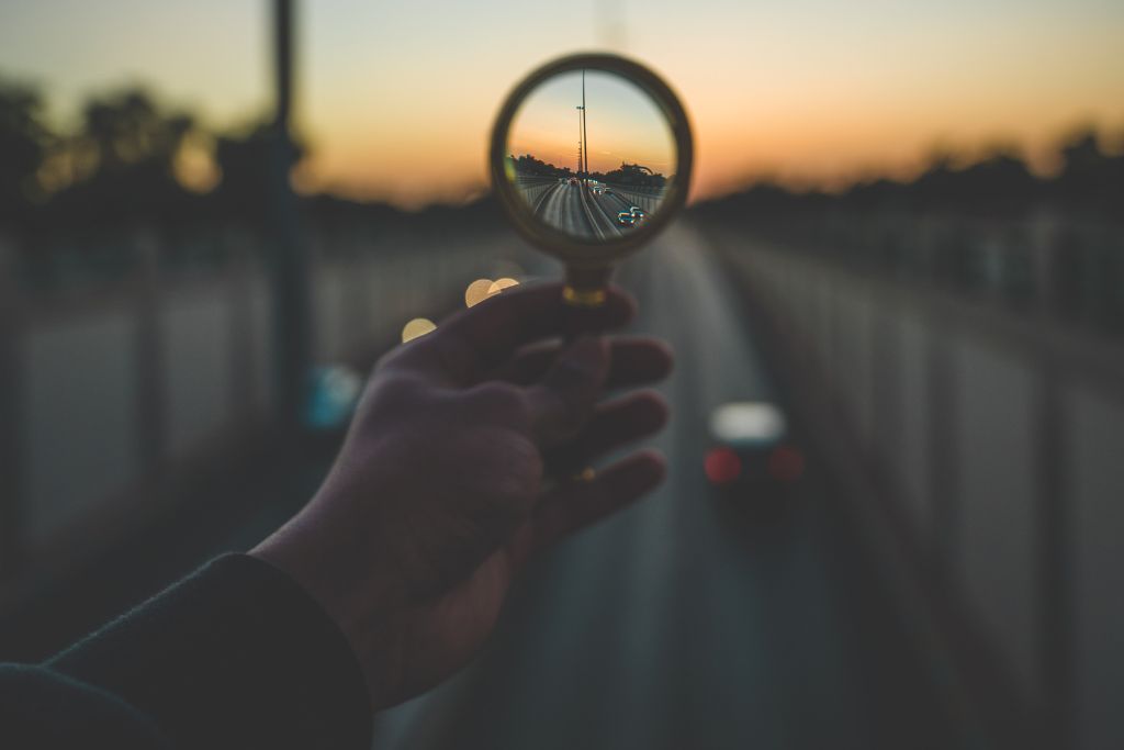 A person is looking through the magnifying glass