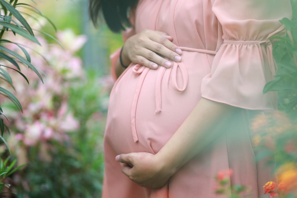 A woman holding her stomach in nature