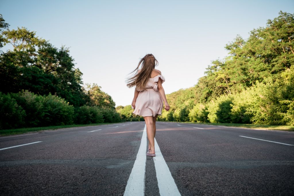 A woman is standing on the middle of the road