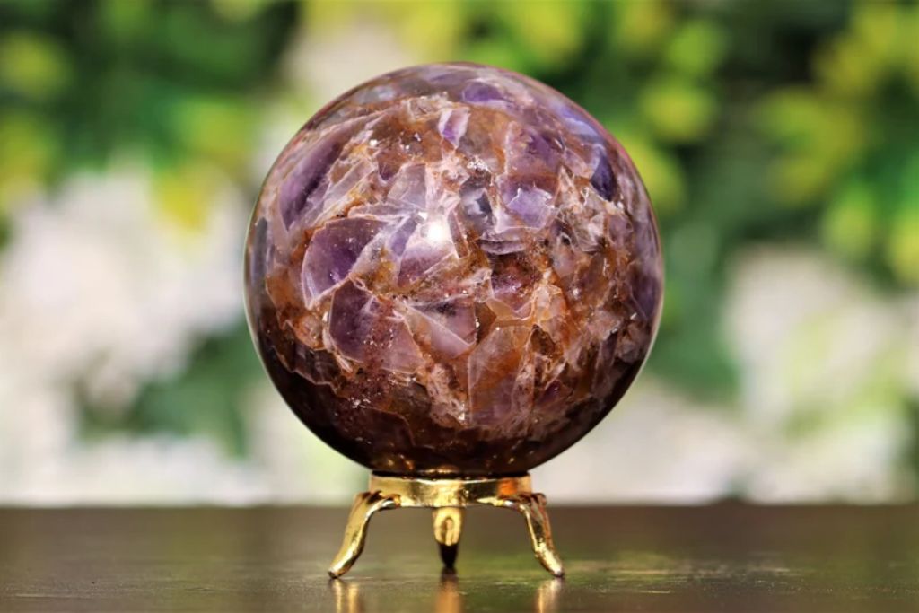 An Auralite 23 crystal sphere on a pedestal. Source: Etsy | AtlantiscrystalsArt