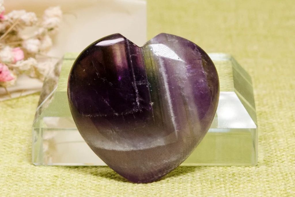 A heart shape Auralite 23 crystal on a table. Source: Etsy | NaturalMineralsArt
