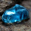 a blue zircon crystal placed on a rock surface. Image source: Flickr x Martin Heigan