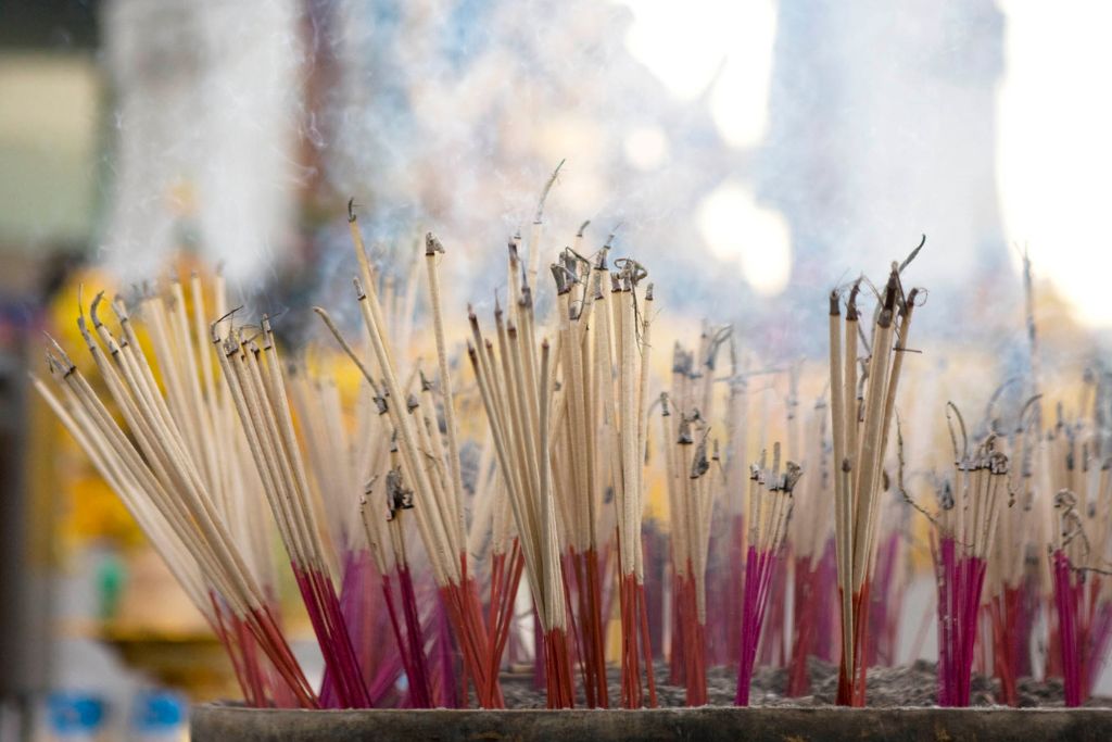Incense sticks that are burning on a big pot