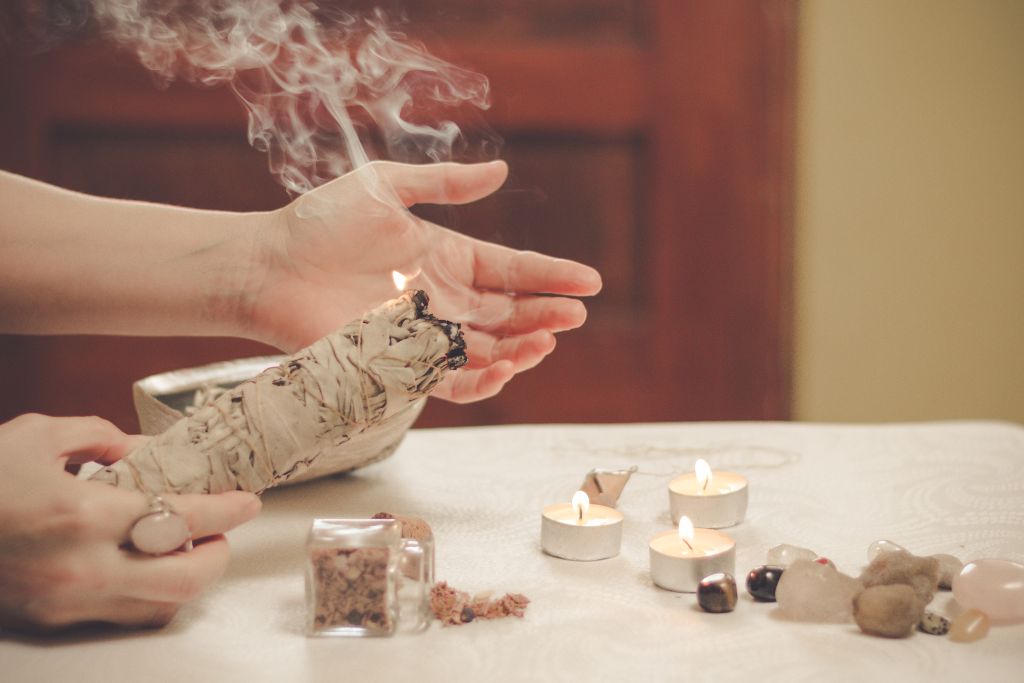 A person is holding a burning sage