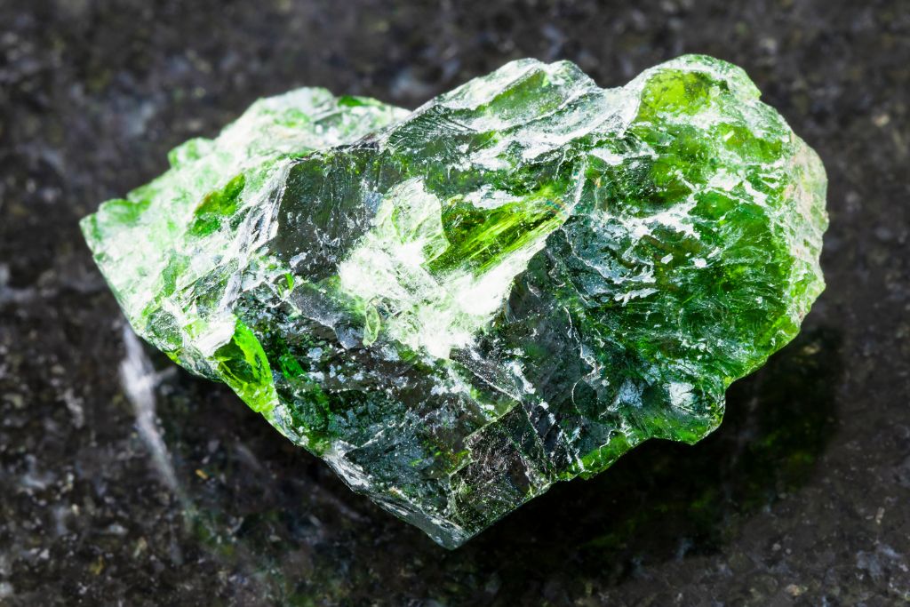 A chrome diopside crystal on a black granite