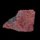 A raw cinnabar crystal on a black background