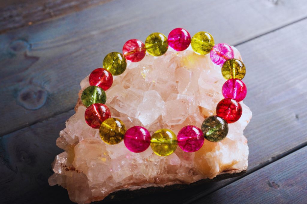 colorful crystal bracelet placed on top of a white crystal geode