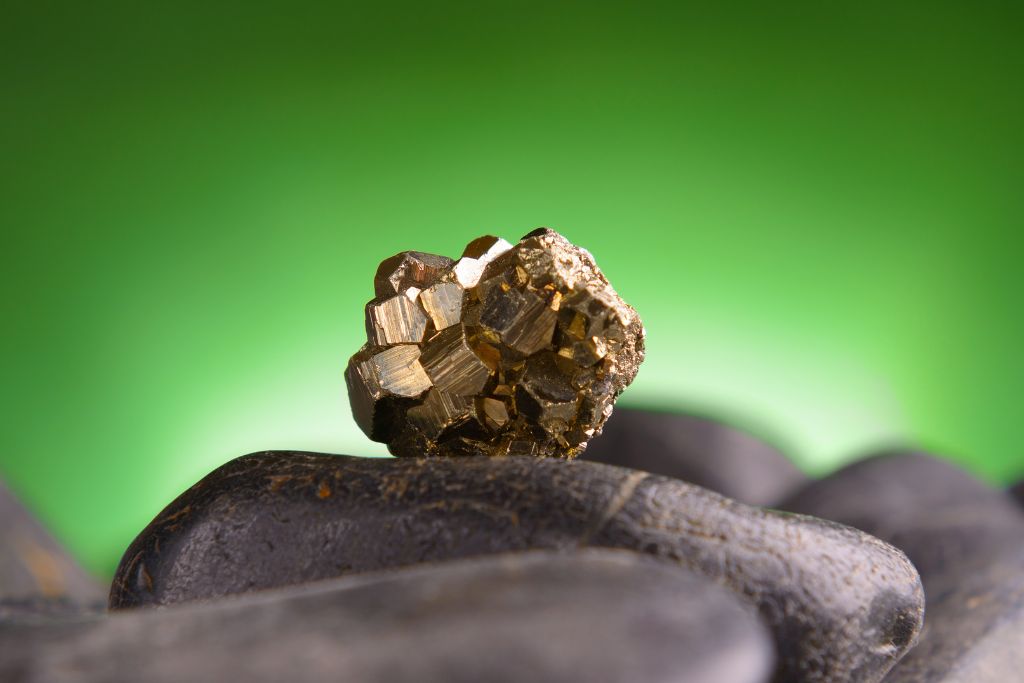 Golden Pyrite crystal focused on top of another stone 