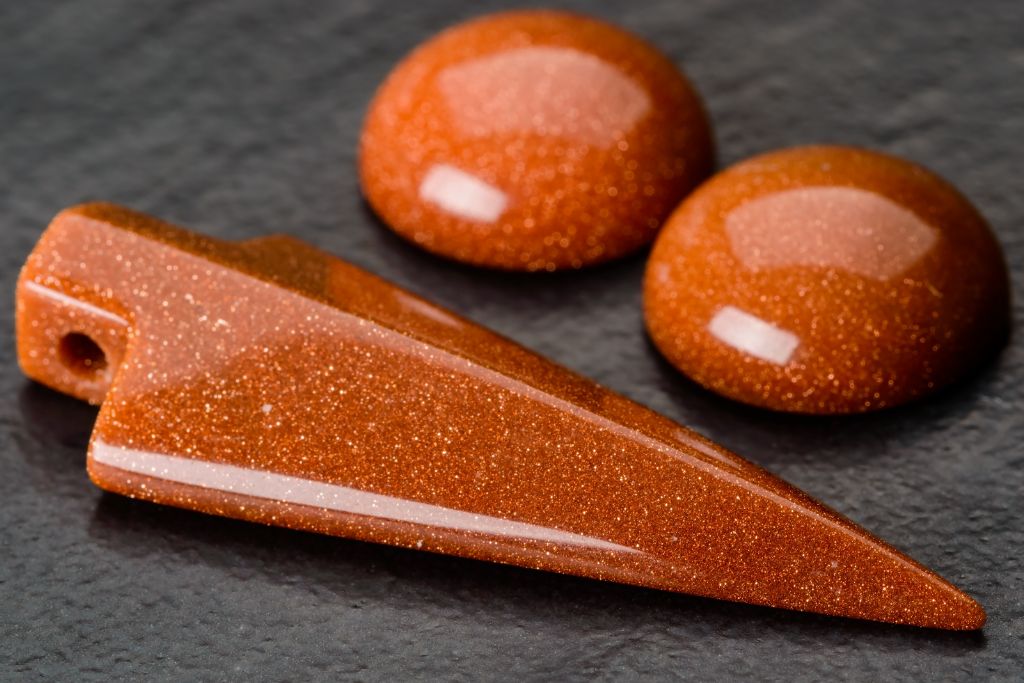 Different shapes of Goldstone Crystals on a dark background