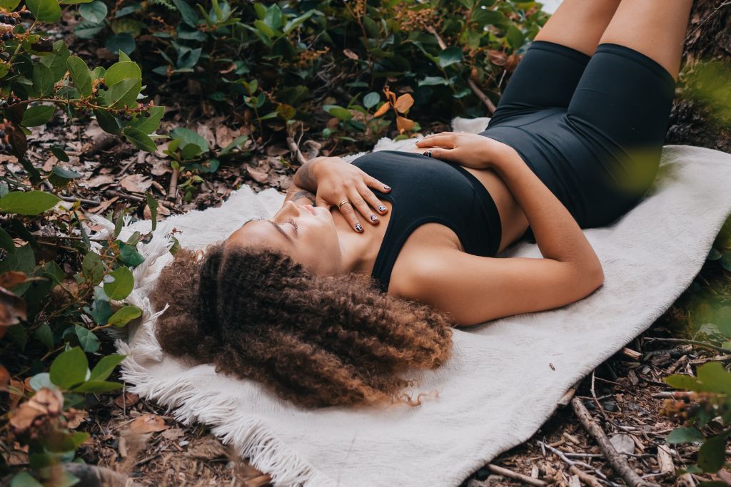 A person laying on the ground feeling a connected with the Earth.