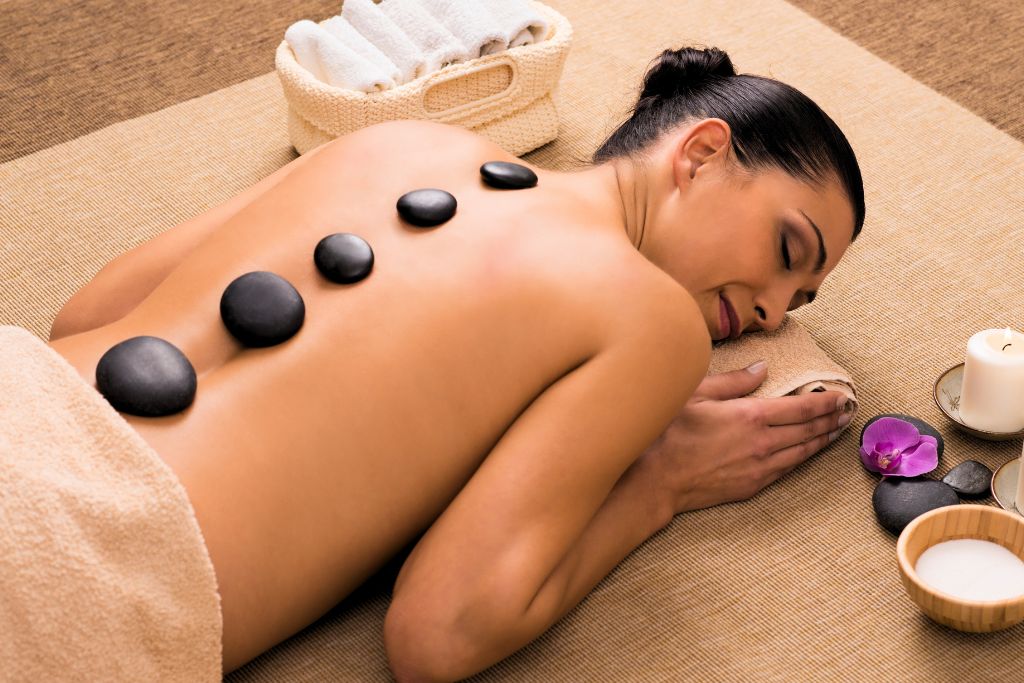 woman having a massage on her back touching her root chakra body part