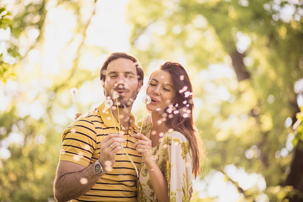 couple having fun and blowing some flowers