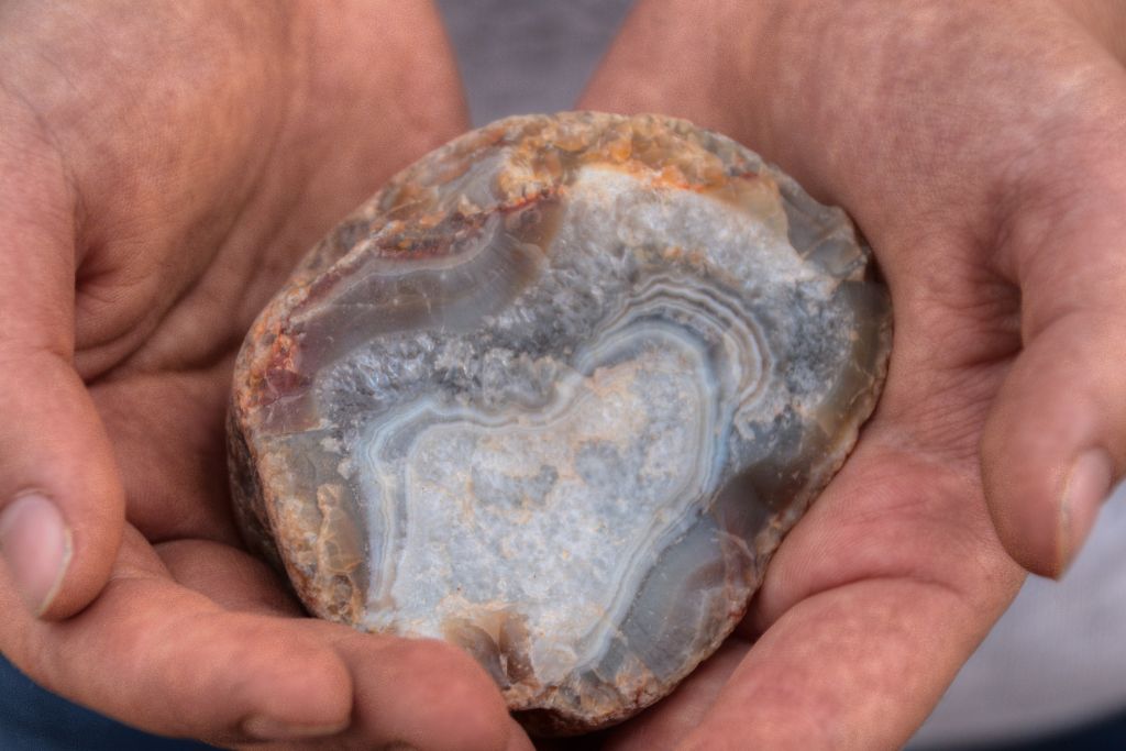 A person holding a lake superior agate on his hands
