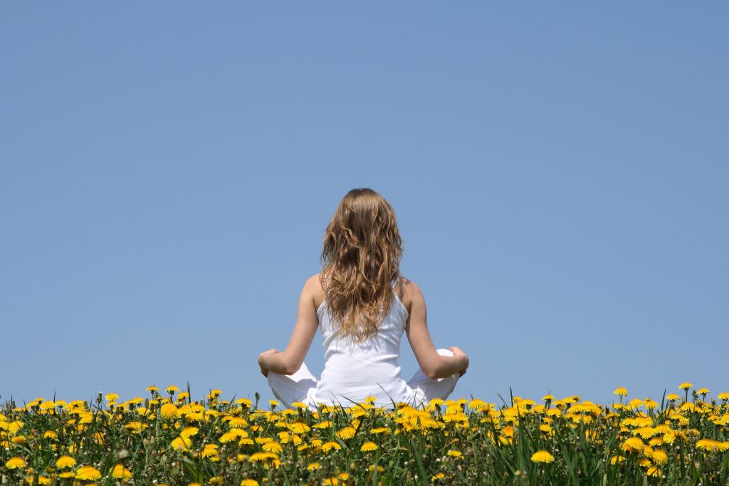 A woman in a flower field meditating