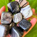 Eight pieces of tumbled Picasso Jasper placed on a hand. Image Source: Etsy | WildandFreePeople: Madi