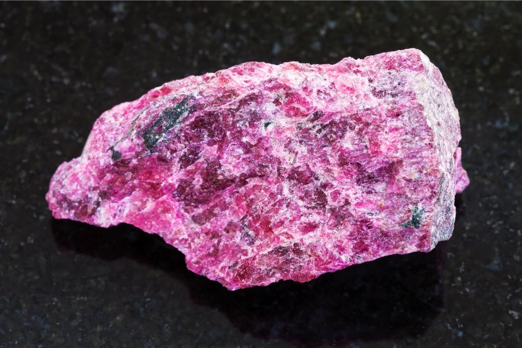 Raw Eudialyte on a black background