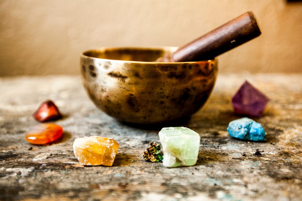 A singing bowl surrounded by different crystals. 