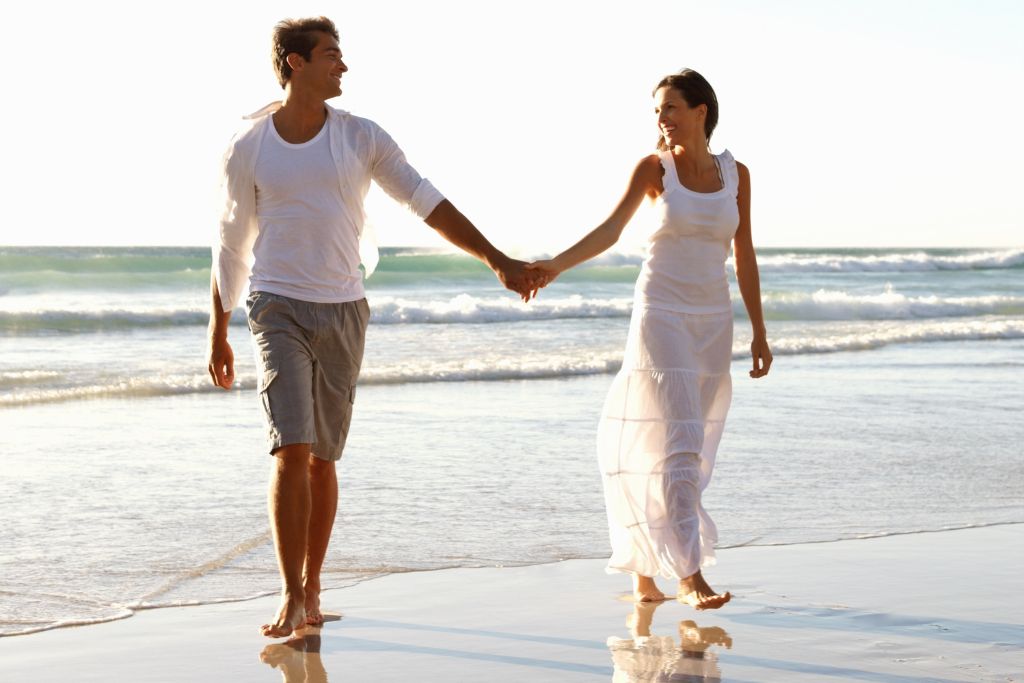 A couple holding each other hands at the beach