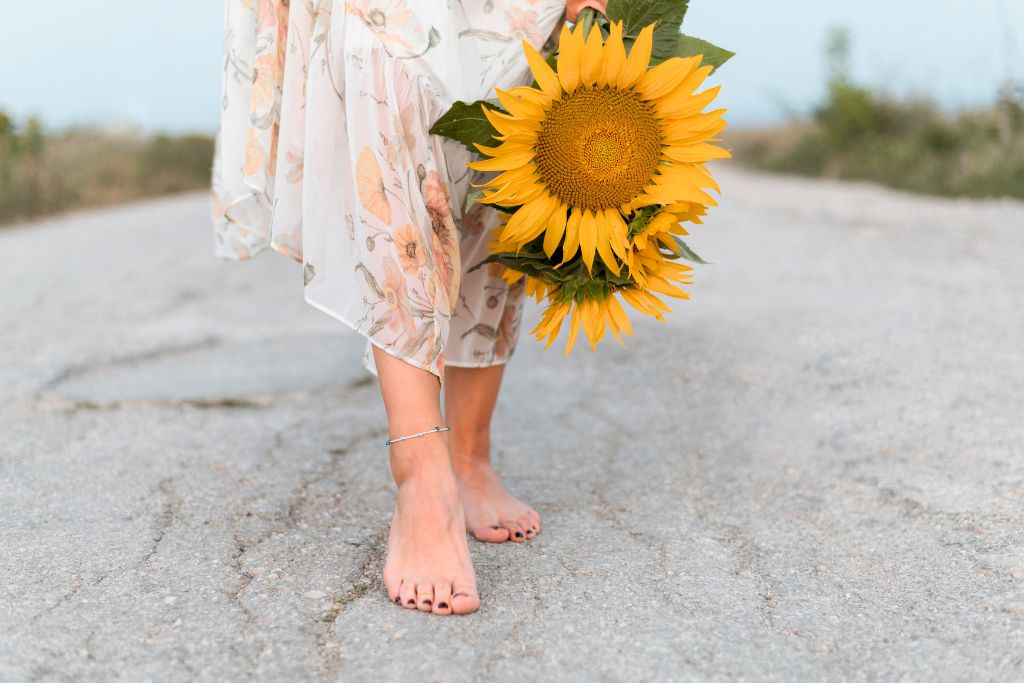 A close up look of a woman walking in the middle of the road barefooted