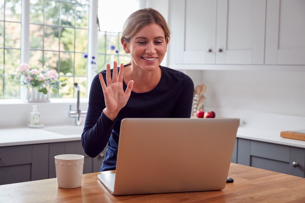 woman happily talking to someone on her laptop 