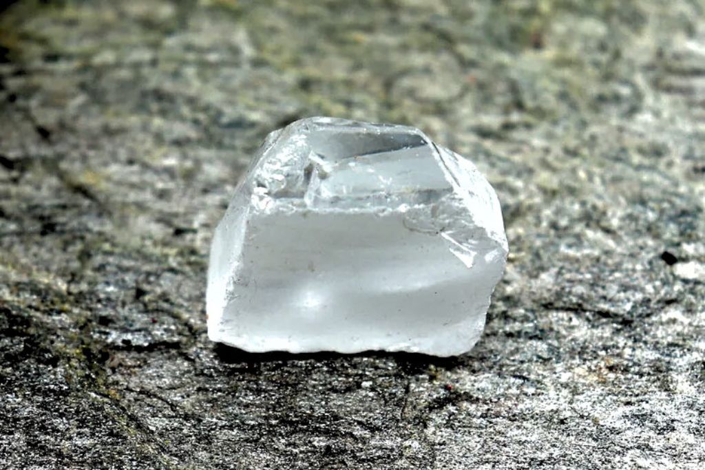 White Sapphire crystal placed on a rock platform. Image Source: Etsy | VeteranGemsNJewels