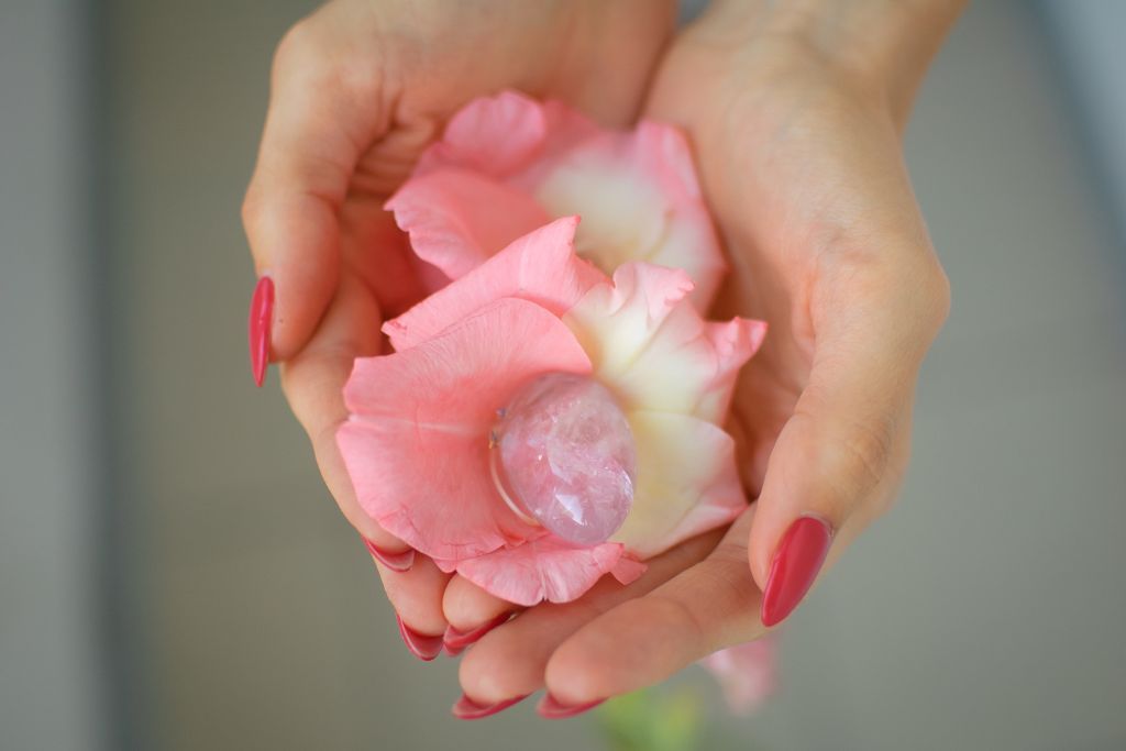 A woman holding a yoni egg with her two hands