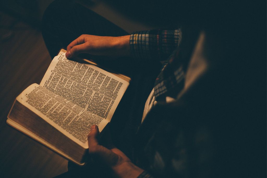 a person sitting and reading the bible