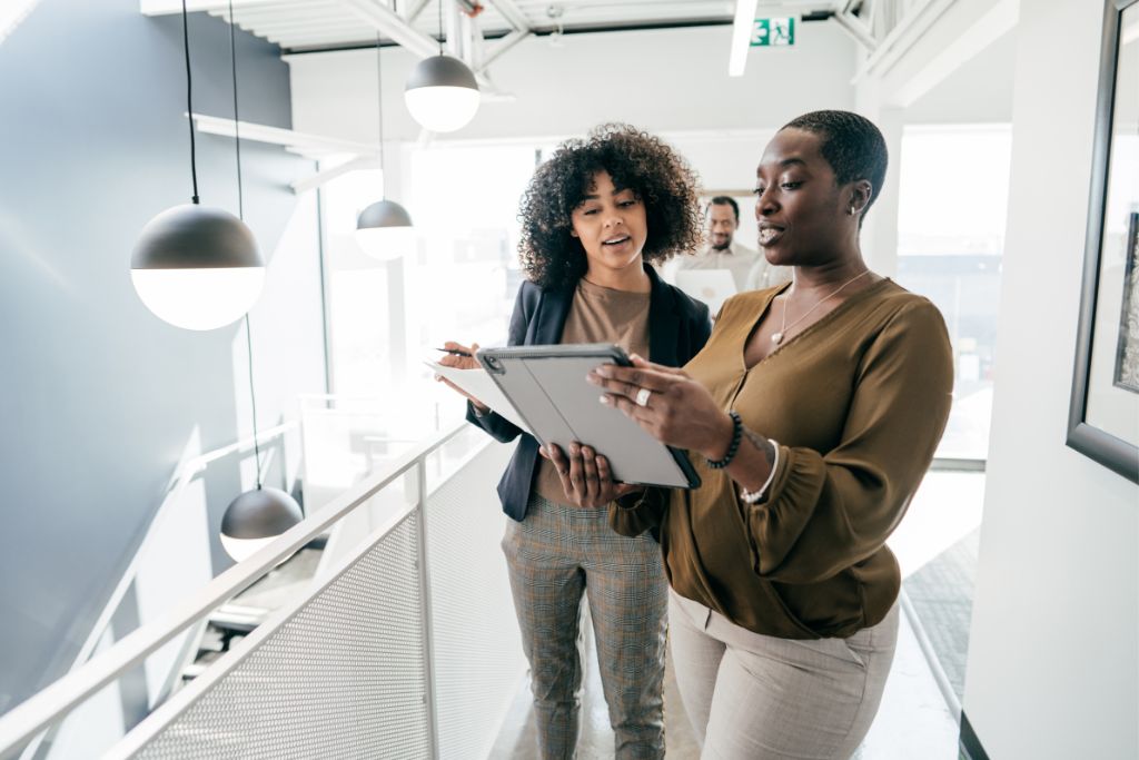 2 women talking and looking at an ipad