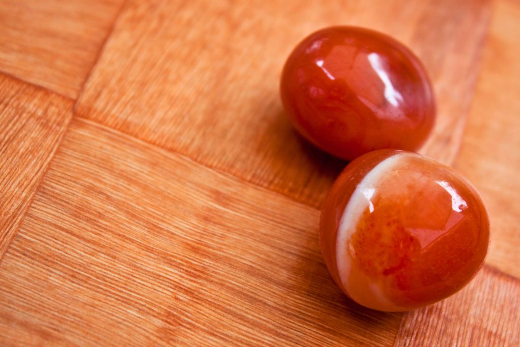 two pieces of polished carnelian crystal on a table