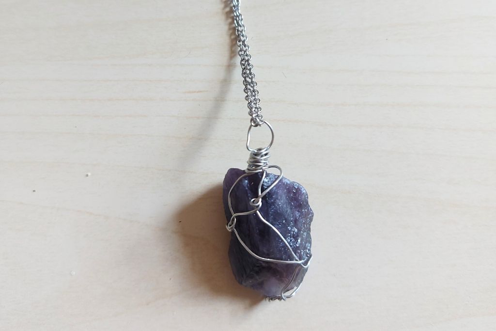 amethyst pendant surrounded by twisted wire and connected with a silver chain