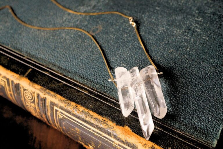 crystal quartz necklace on top of vintage book cover